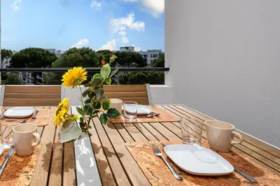 a wooden table with plates and a vase of flowers on it at Vilamoura - Spacious with Swimming Pool & View in Vilamoura