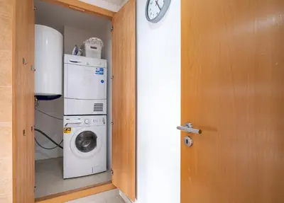 a laundry room with a washing machine and a clock at Vilamoura - Spacious with Swimming Pool & View in Vilamoura
