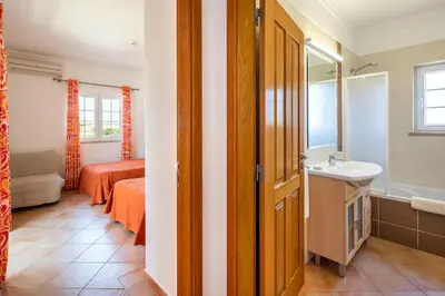 a bathroom with a sink and a bedroom with a bed at Private Villa Ribeiro I Heated Pool, 4 Bed, BBQ, AC, WIFI, BEACH in Albufeira