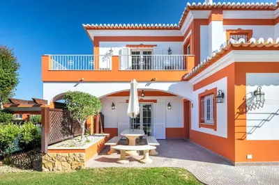 a house with a patio and a table in front of it at Private Villa Ribeiro I Heated Pool, 4 Bed, BBQ, AC, WIFI, BEACH in Albufeira