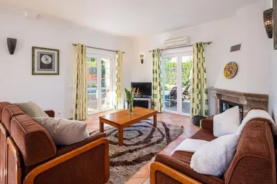a living room with two couches and a fireplace at 4 Bed Private Villa Ribeiro II with heated pool, garden, wi-fi in Albufeira