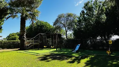 a playground in a yard with a tree at Bicos 7 by Check-in Portugal in Albufeira