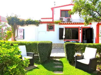 a yard with two chairs and a house at CH 7 - One Bedroom Apartment, Casa da Horta, Pool and Garden in Albufeira