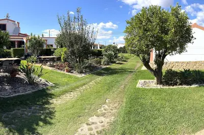 a garden with a tree and grass and a building at CH 7 - One Bedroom Apartment, Casa da Horta, Pool and Garden in Albufeira