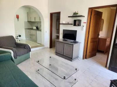 a living room with a couch and a glass table at CH 7 - One Bedroom Apartment, Casa da Horta, Pool and Garden in Albufeira