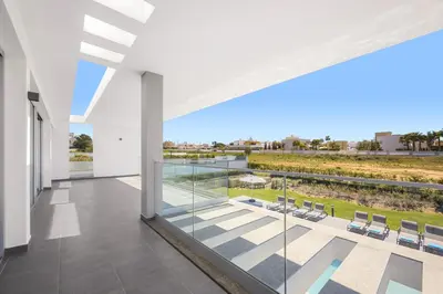 an indoor balcony with a view of a pool and chairs at Villa Casa Lirio by Villa Plus in Galé