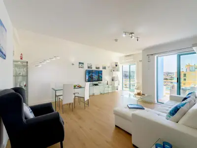 a white bedroom with a bed and a dresser at Apartment The LightHouse by Interhome in Albufeira