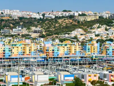 a marina with blue umbrellas and boats in the water at Apartment The LightHouse by Interhome in Albufeira