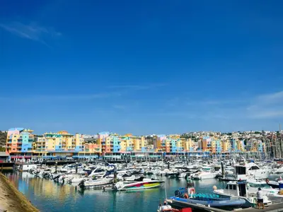 a couple of boats docked in a harbor with a city at Apartment The LightHouse by Interhome in Albufeira