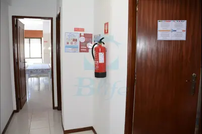 a fire extinguisher on the side of a refrigerator at Blife Julya private rooms in Faro
