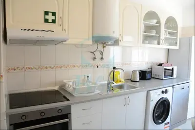 a white kitchen with a sink and a dishwasher at Blife Julya private rooms in Faro