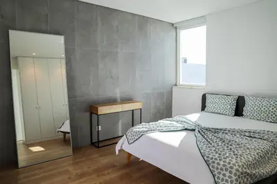 a bedroom with a large bed and a mirror at Villa Central By Garvetur in Quarteira