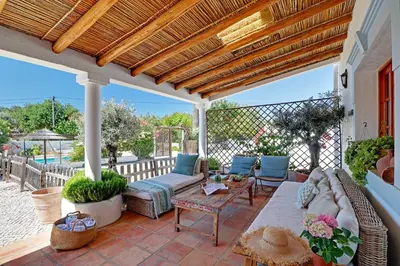 a porch with a couch and chairs on a patio at Quinta Grande de Boliqueime by Portucasa in Boliqueime