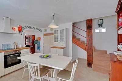 a kitchen with a white table and chairs in a room at Quinta Grande de Boliqueime by Portucasa in Boliqueime