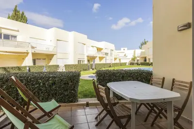 a table and chairs on a patio in front of a building at Terracos Falesia II - Terrace with pool by HD in Vilamoura