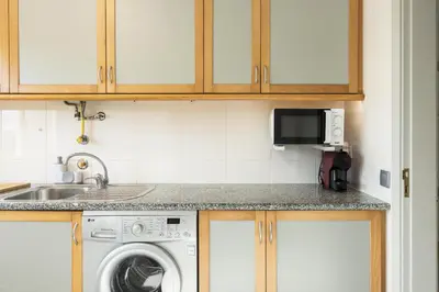 a kitchen with a sink and a washing machine at Terracos Falesia II - Terrace with pool by HD in Vilamoura