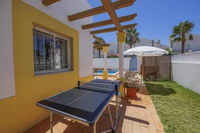a patio with a table and an umbrella at Villa Algarhb by Villa Plus in Albufeira