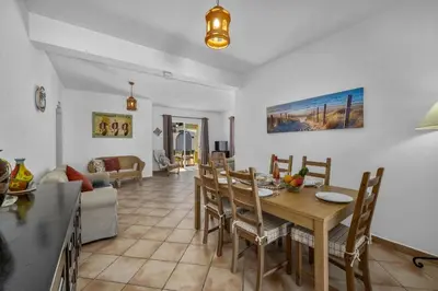 a dining room and living room with a table and chairs at Villa Algarhb by Villa Plus in Albufeira