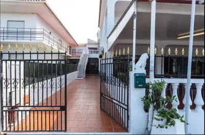 a building with a gate and a walkway at Blife Aerya private rooms - Airport stay in Faro
