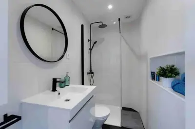 a white bathroom with a sink and a mirror at Cozy studio near the beach in Quarteira