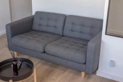 a blue couch in a living room with a table at Cozy studio near the beach in Quarteira