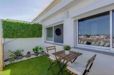 a small balcony with a wooden table and chairs at Cozy studio near the beach in Quarteira