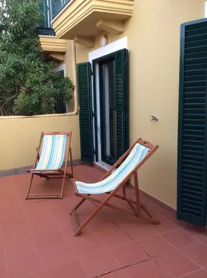 two chairs sitting on a patio next to a building at Vila Bairos Apartment Vilamoura in Vilamoura