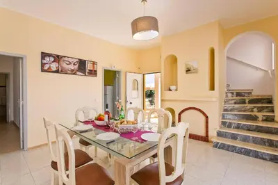 a dining room with a glass table and chairs at Villa Carlos by Villa Plus in Galé