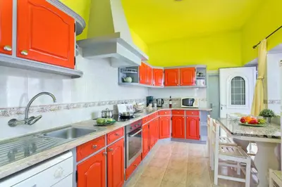 a kitchen with orange and yellow cabinets and a sink at Villa Carlos by Villa Plus in Galé