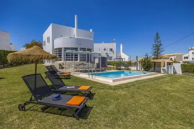 a yard with two chairs and a swimming pool at Villa Casa Duarte by Villa Plus in Olhos de Água
