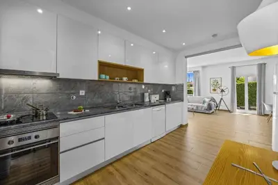 a kitchen with white cabinets and a wooden floor at Villa Casa Duarte by Villa Plus in Olhos de Água
