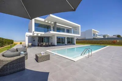 a villa with a swimming pool in front of a house at Villa Casa Gardenia by Villa Plus in Galé