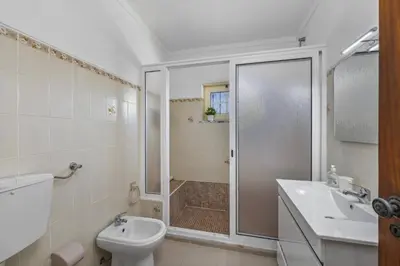 a bathroom with a shower and a toilet and a sink at Villa Casa Lourenco by Villa Plus in Albufeira