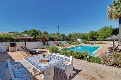 a patio with a table and a swimming pool at Quinta Boliqueime by Portucasa in Boliqueime