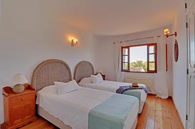 a bedroom with two beds and a window at Quinta Boliqueime by Portucasa in Boliqueime