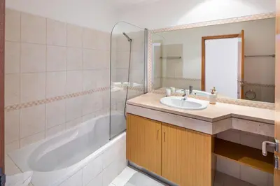 a bathroom with a sink and a tub and a mirror at Appartement Vista das ondas in Olhos de Água