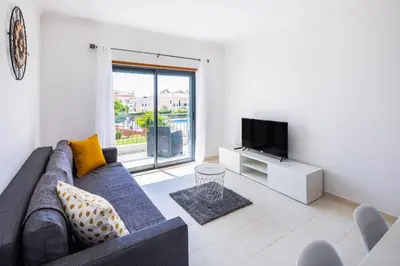 a living room with a couch and a tv at Appartement Vista das ondas in Olhos de Água