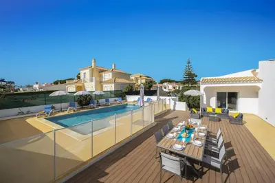 a patio with a table and chairs next to a pool at Villa Duas Sentinelas by Villa Plus in Cabeço de Câmara