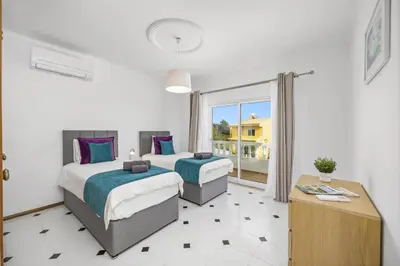 a bedroom with two beds and a large window at Villa Duas Sentinelas by Villa Plus in Cabeço de Câmara