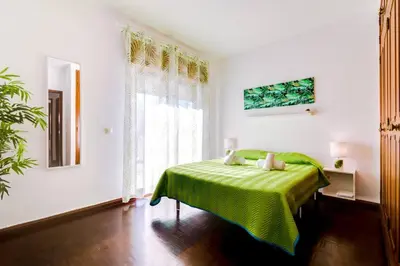 a green bed in a white room with a window at Blife Anya private rooms in Faro