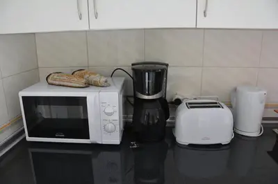a microwave and a toaster on a kitchen counter at Blife Chelsya private rooms in Faro