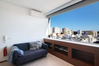 a living room with a large window with a city view at Casa Alameda in Faro