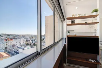 a living room with a tv and a large window at Casa Alameda in Faro