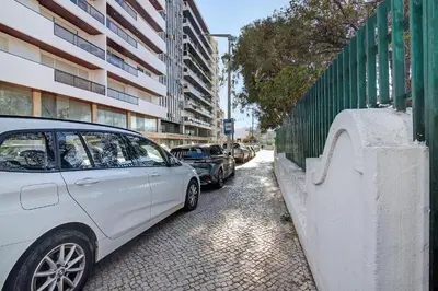 a white car parked on a street next to a fence at Casa Alameda in Faro