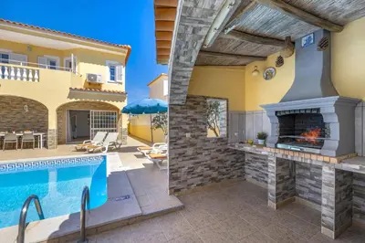 a house with a swimming pool and a fireplace at Villa Graca by Villa Plus in Albufeira