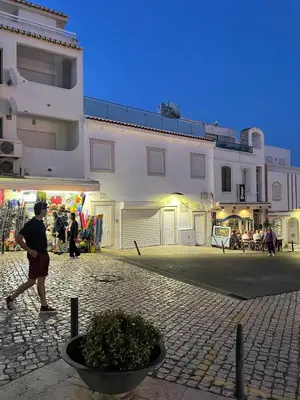 a man walking in front of a white building at Casa Tapada do Bento I- Albufeira in Albufeira