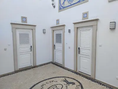 a room with three doors and a rug on the floor at Casa Tapada do Bento I- Albufeira in Albufeira