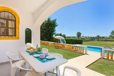 a patio with a table and chairs and a pool at Villa Lurdes by Villa Plus in Galé
