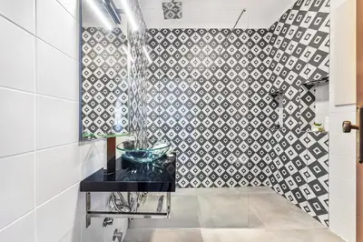 a bathroom with a black counter and a tile wall at Loendros, Calma Moradia com Piscina Privada, Guia in Guia