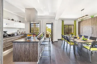 a kitchen with a long bar with yellow chairs at Loendros, Calma Moradia com Piscina Privada, Guia in Guia